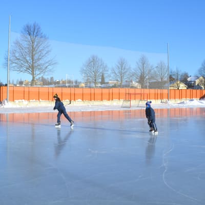 Två barn spelar ishockey
