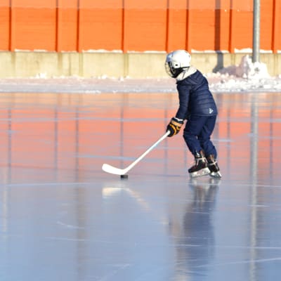 ett barn spelar ishockey