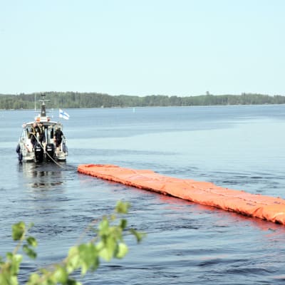 Pelastuslaitos vetää öljyntorjuntapuomia veneellä Saimaalla Lappeenrannan Joutsenossa kesäkuussa 2019.