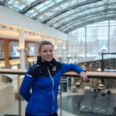 Nuori nainen nojaa hymyillen kaiteeseen kauppakeskus Stellassa. 