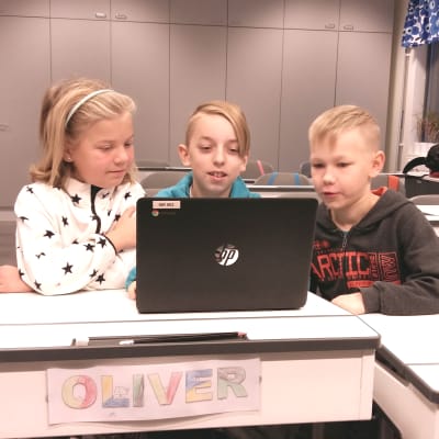 Emilia Eriksson, Oliver Helenius och Lasse Rantanen sitter vid en dator i Kirjala skola.