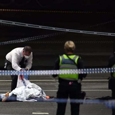 En polis inspekterar dödsoffret på attentatsplatsen i Melbourne på fredagen. 