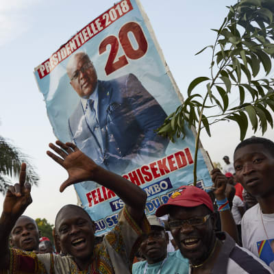 Felix Tshisekedin kannattajat huutavat ja kannattelevat suurta kylttiä, jossa on Tshisekedin kuva.