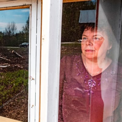 Tuija Rautiainen katsoo entisen kotinsa ikkunasta.