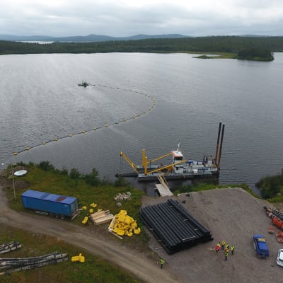 Stora Enson Kemijärven entisen sellutehtaan jätejärvi. Kuvassa ruoppauskone ja keltaisilla kellukkeilla oleva putki, jota pitkin pohjaan kasautunut ongelmajäte pumpataan jätesäkkeihin kuivumaan. Kemijärvi 21.8.2019