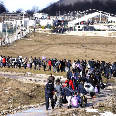 Siirtolaiset jättävät palavan leirin Bosniassa.
