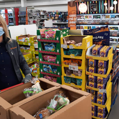 kauppias kerää laatikkoon ruokaa