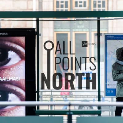 Photo of woman waiting at bus stop in Helsinki featuring All Points North podcast logo.
