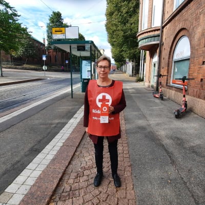 Regina Laurén från Röda korset står iklädd insamlingsväst utanför kontoret i Helsingfors.