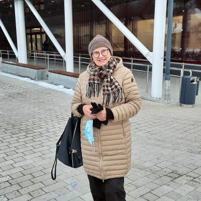 En kvinna står utanför en välfärdscentral i Kyrskslätt.
