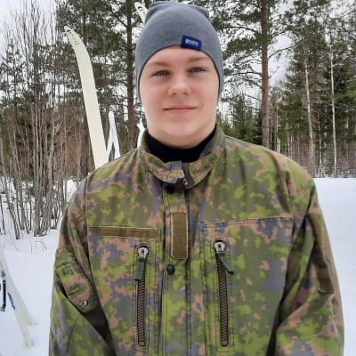 Joakim Påfs katsoo kameraan metsäleirillä.