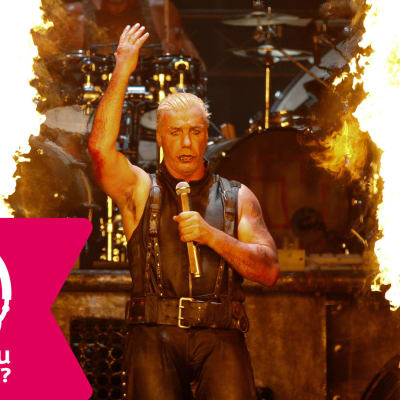 Sångaren Till Lindemann i Rammstein på scenen inramad av två stora eldstoder.