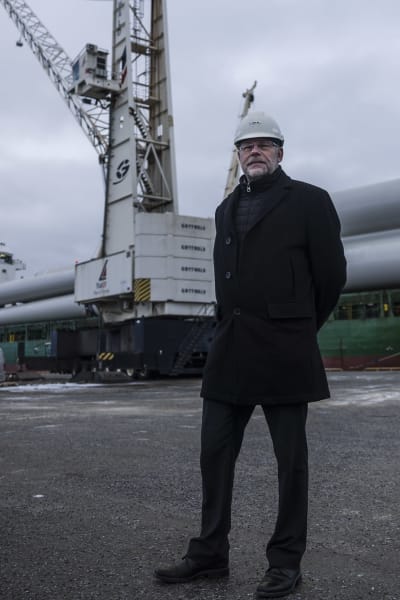Porträttfoto på Patrik Hellman framför fraktfartyg