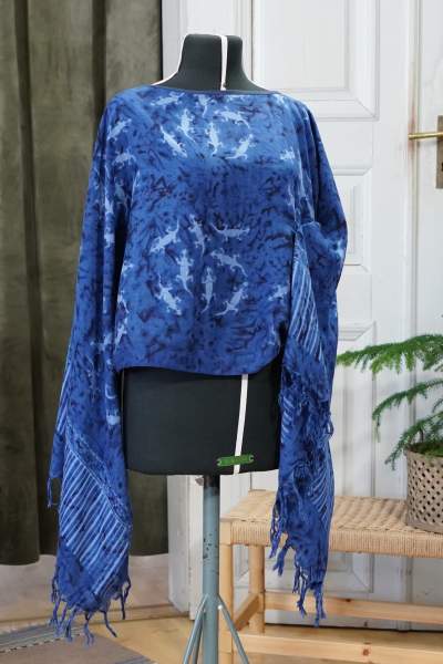 En blå blus med fransar i ärmarna och mönster med ödlor.