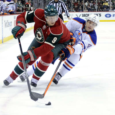 Minnesota Wildin Mikko Koivu (vas.) kuljettaa kiekkoa Edmonton Oilersin Taylor Hallin (oik.) edestä.