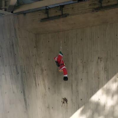 Joulupukkihahmo Kuokkalan sillan alla keinumassa.
