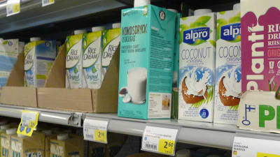 en butikshylla med några olika sorter och kartonger av växtmjölk.