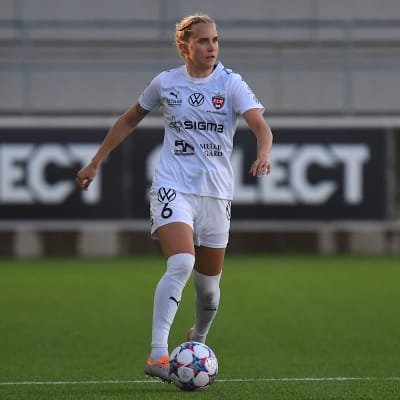Ria Öling med boll på fotbollsplanen. 