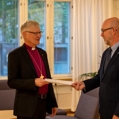 Piista Häkkinen hymyhuulin ojentamassa eroilmoitustaan lakimiesasessori Jyri Klemolalle.