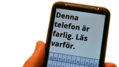smarttelefon med texten: denna telefon är farlig. läs varför. på skärmen