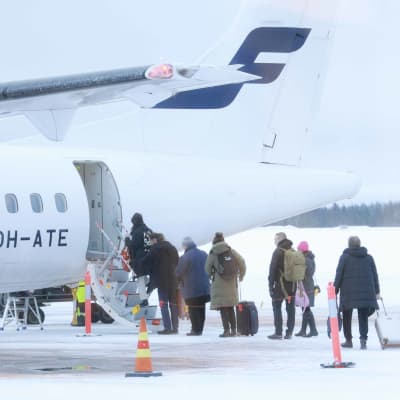 Kajaanin lentokenttä 29.12.2022. Matkustajat nousevat Finnairin potkurikoneeseen.