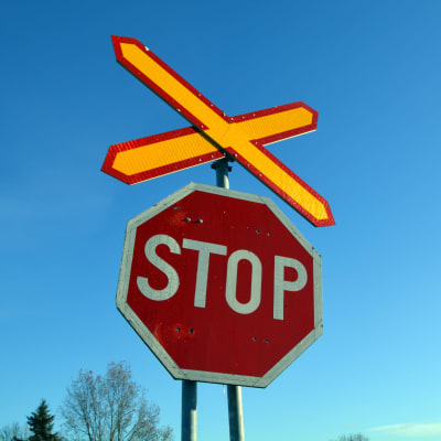 Stop-merkki rautatien tasoristeyksen kohdalla.