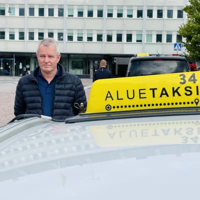 Taksikuljetaja Pentti Mattila pitää hiljaisen hetken poismenneen kolleegan muistoksi.