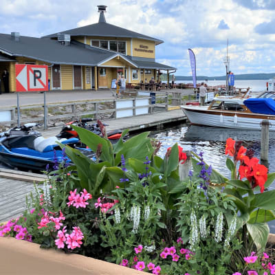 Veneet on parkissa venesatamassa Vääksyssä. Taustalla on keltainen ravintolarakennus.