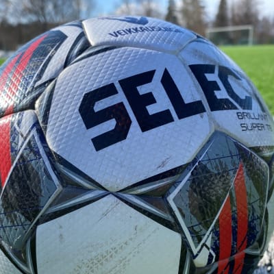 Veikkausliigan virallinen jalkapallo Select kulmapotkupaikalla, lähikuva pallosta nurmikolla.