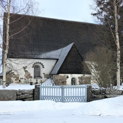 Isonkyrön vanha kirkko talvimaisemassa kuvattuna muurin ulkopuolelta.