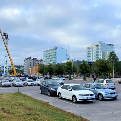 Kuva Ranta-Kartanon alueesta Lahdessa. Autoja parkkipaikalla pysäköitynä, taustalla nostukurki ja aidattu työmaa.
