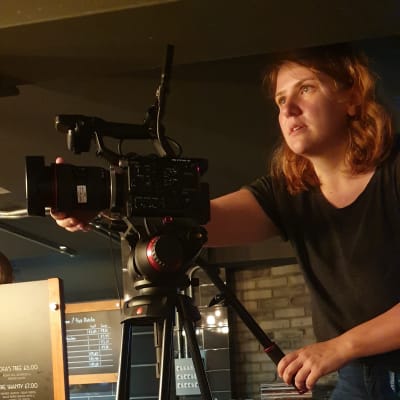 Frida Johansson filmar med en filmkamera.