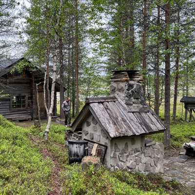 Perinteinen harmaa hirsimökki ja piharakennus erämaassa.