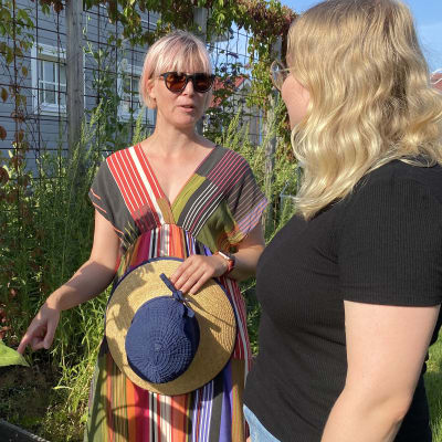 Anni Honkajuuri ja Julia Rantanen ihailevat auringonkukkaa Honkajuuren puutarhassa.