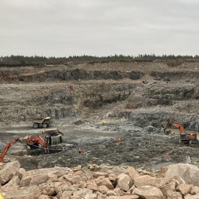 Kaivonkoneet ja kuljetusautot kaivavat kultamalmia Raahen kaivoksella.