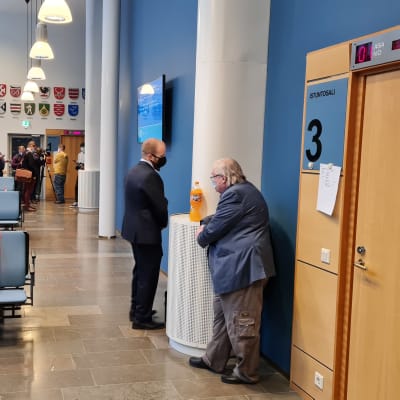 Målsägande Pekka Kataja (till höger) i tingsrättens korridor.