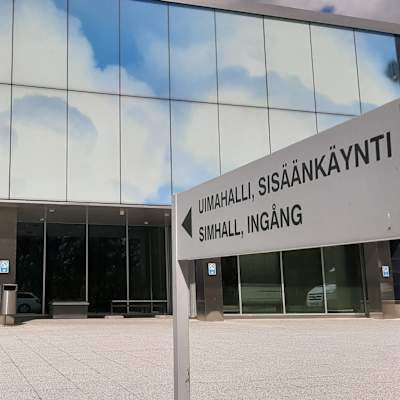 En skylt visar var ingången till en simhall finns.