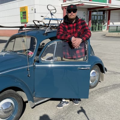 Mies seisoo Wolkwagen Kuplan ovenraossa. 