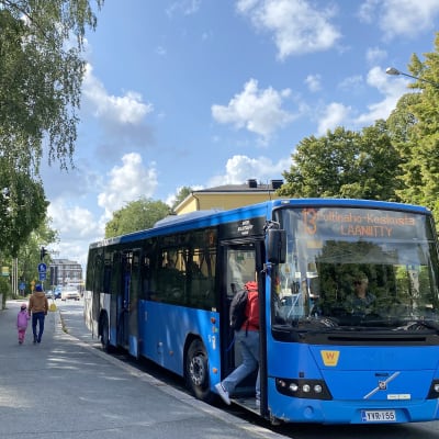 Sinen paikallisbussi pysähtyneenä pysäkille.