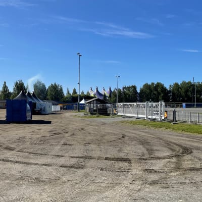 Hiekkakentällä on tilapäisiä telttoja ja aitoja.