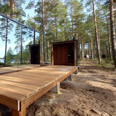 Peilimökki Pyhtään Verssonkankaalla. Mökki heijastaa pelikuvaa ympäristöön. 