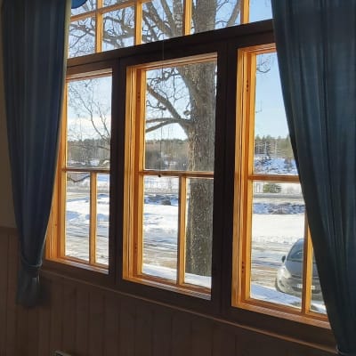 En vägg med fönster genom vilka man ser ett vinterlandskap.