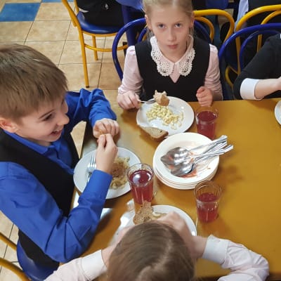 Bild ovanifrån av ryska barn som äter skolmat.