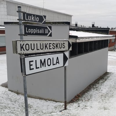 Liikennemerkkejä, joissa tekstit Lukio, Loppisali, Koulukeskus ja Elmola Lopen yhtenäiskoulun rakennuksen edustalla.