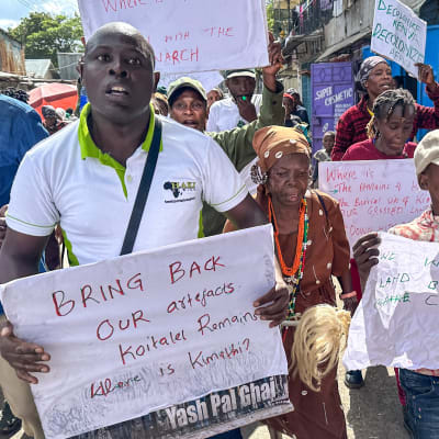 Mielenosoittajia Nairobissa, kyltit käsissä kohti kameraa iskulauseita huutaen