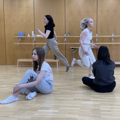 Fyran flickor dansar i en gymnastiksal. 