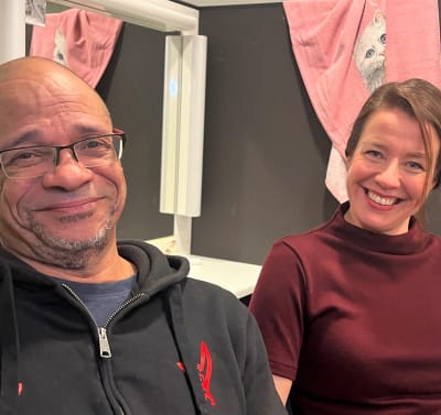 Henry Hanikka ja Eriikka Väliahde istuvat sohvalla ja katsovat hymyillen kameraan.