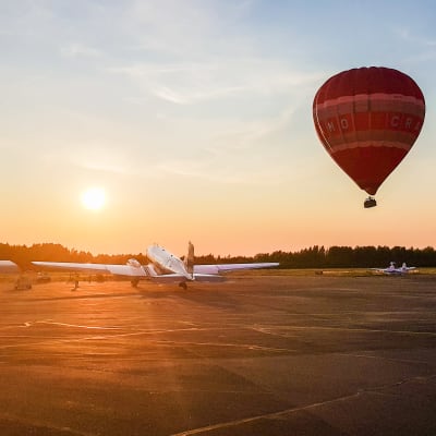 En ballong landar på Malms flygplats. I bakgrunden solnedgång.