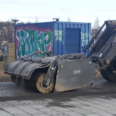 Hiekoitushiekkaa poistava traktori Jyväskylässä Lutakonaukion laidalla.