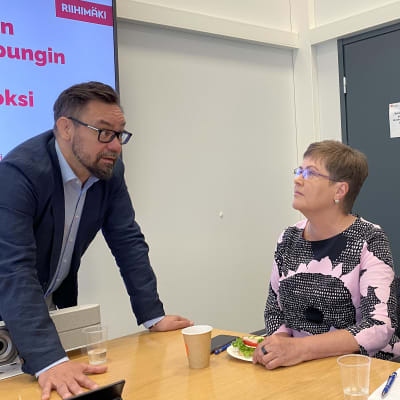 Riihimäen vt. kaupunginjohtaja Petri Hirvonen sekä valtuutetut Riitta Takala ja Kari Vilkman keskustelevat kokoushuoneen pöydän äärellä.